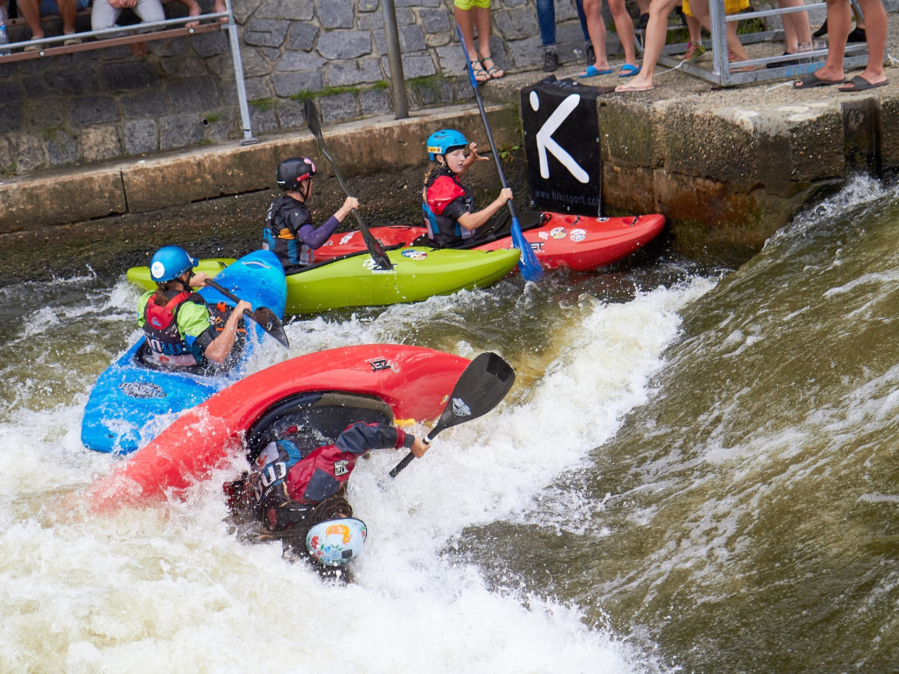 Kayakcross final heat with four kayaks at the final touch banner.